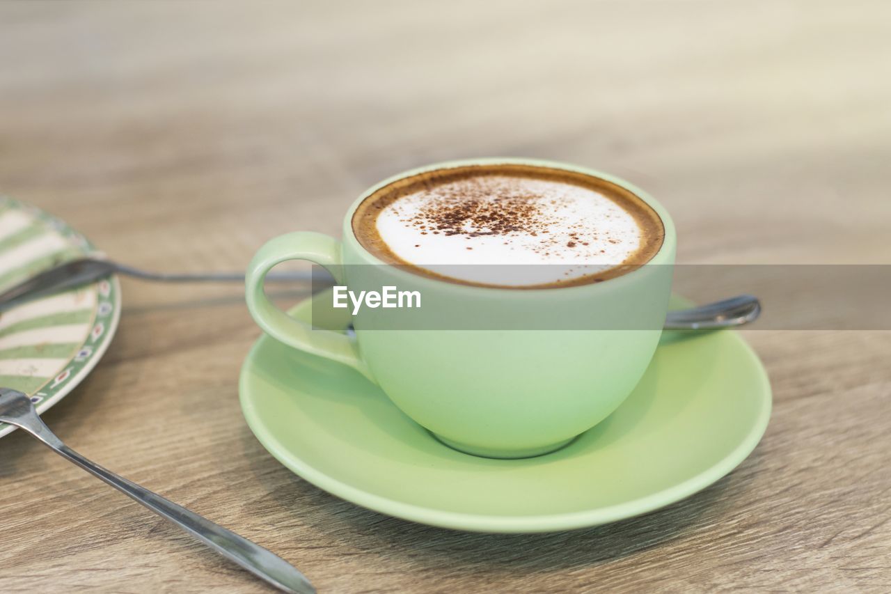 CLOSE-UP OF CUP OF COFFEE ON TABLE