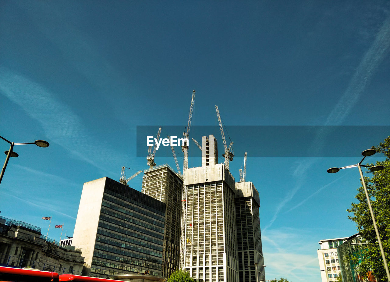 LOW ANGLE VIEW OF BUILDINGS AGAINST CLEAR BLUE SKY