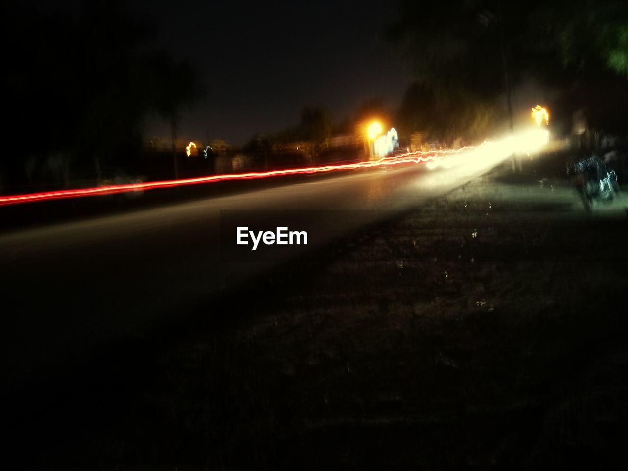 ILLUMINATED LIGHT TRAILS ON ROAD AT NIGHT