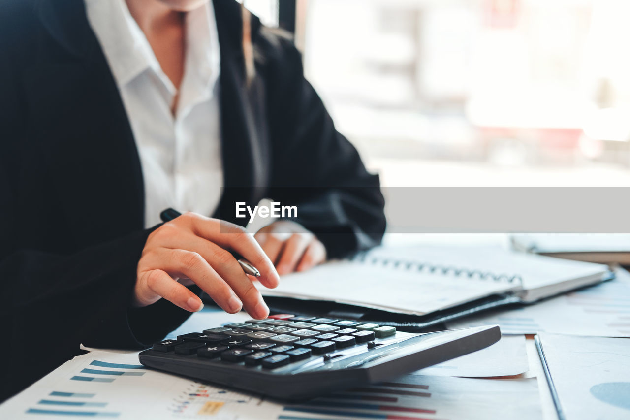 Midsection of business woman working in office