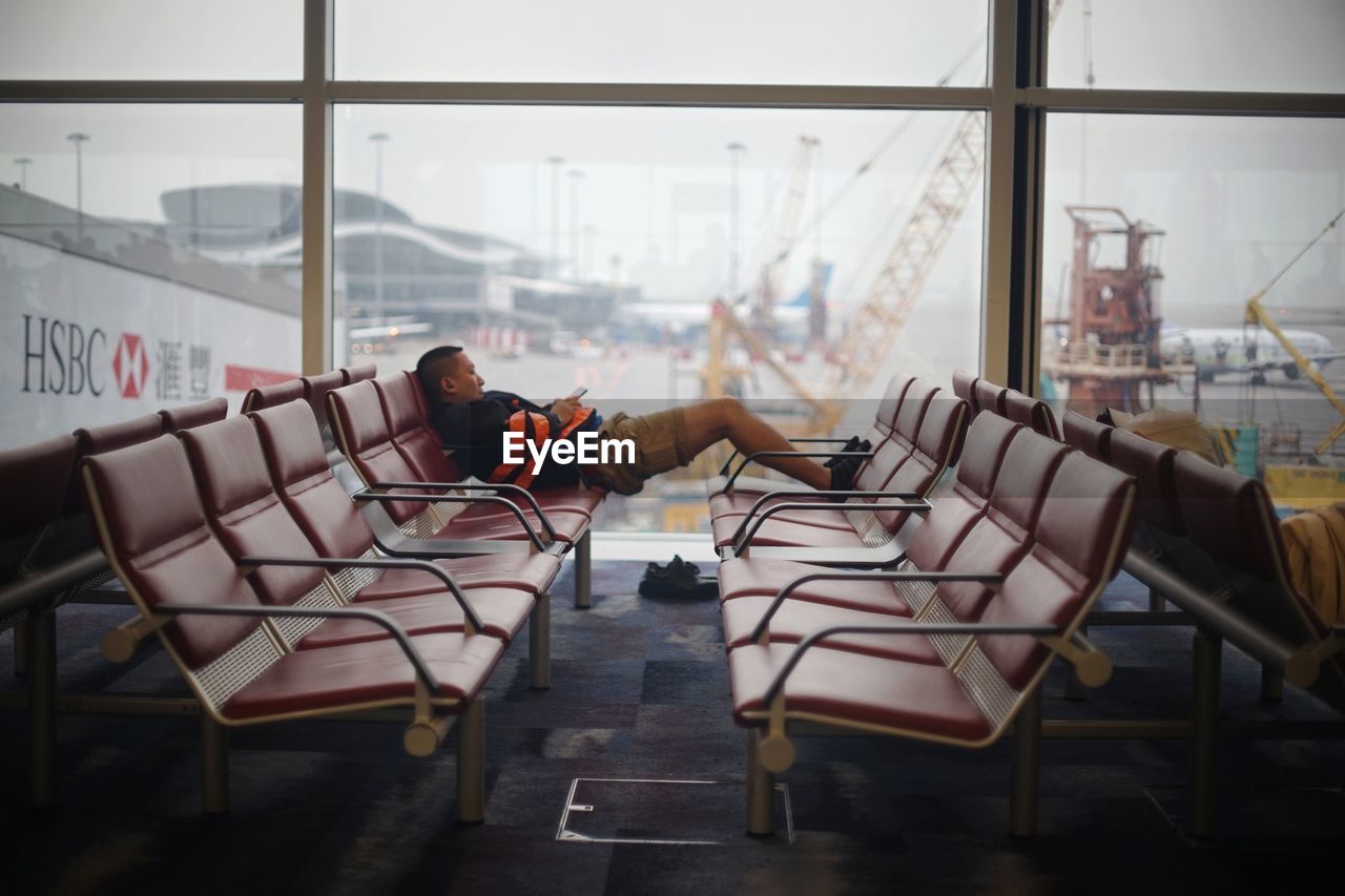 SIDE VIEW OF MAN RELAXING ON SEAT