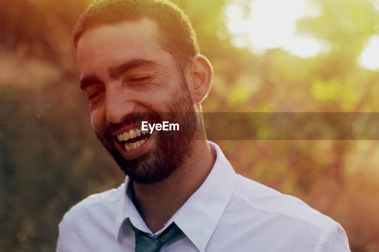 Happy businessman laughing during sunset