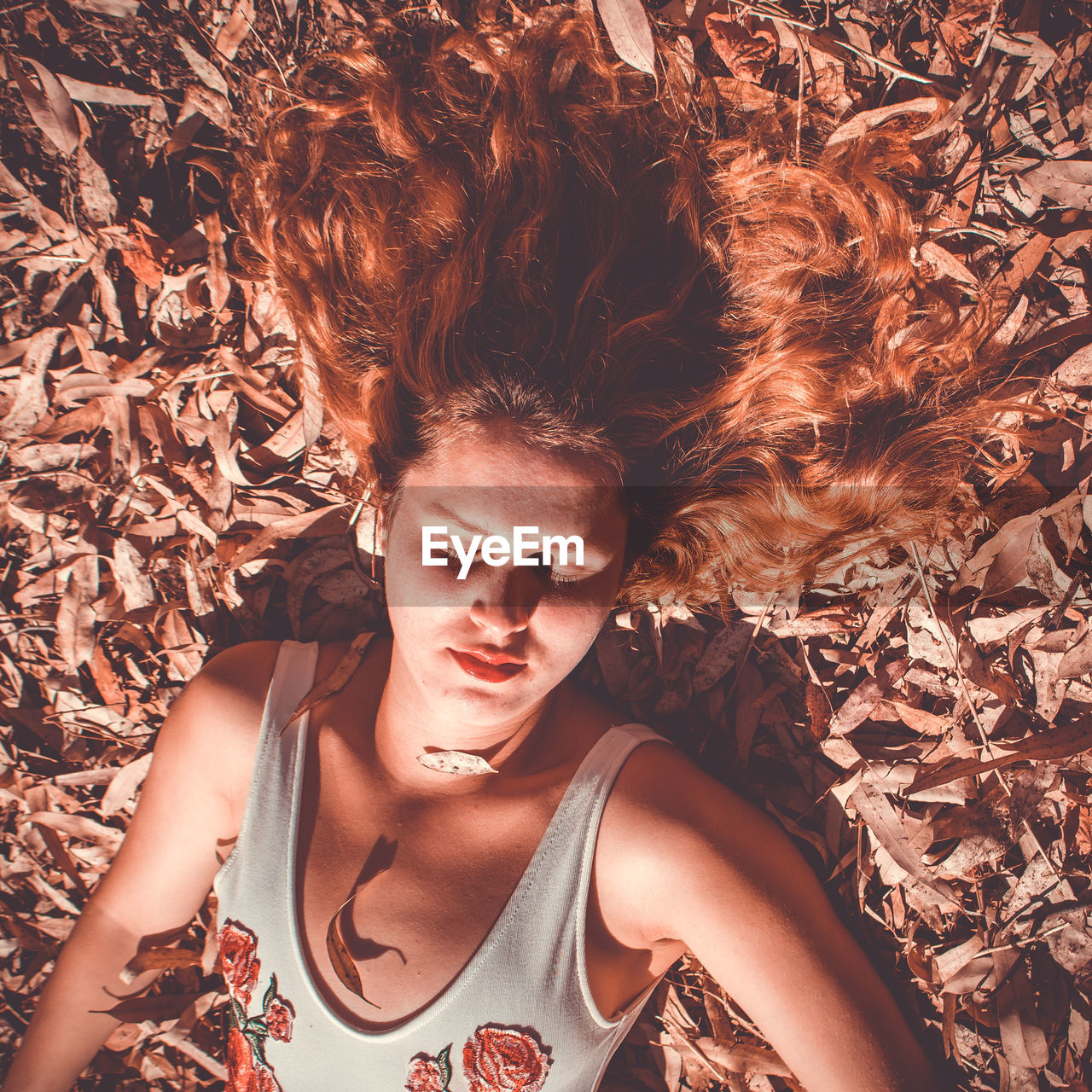 PORTRAIT OF BEAUTIFUL YOUNG WOMAN LYING DOWN ON LAND