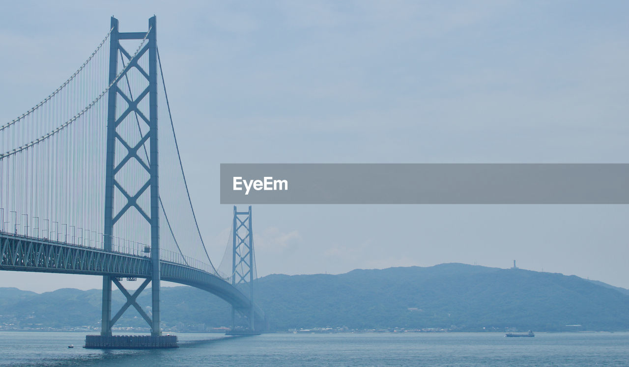 Suspension bridge over sea against sky