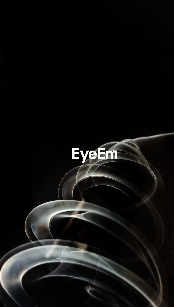 CLOSE-UP OF SPIRAL LIGHT OVER BLACK BACKGROUND