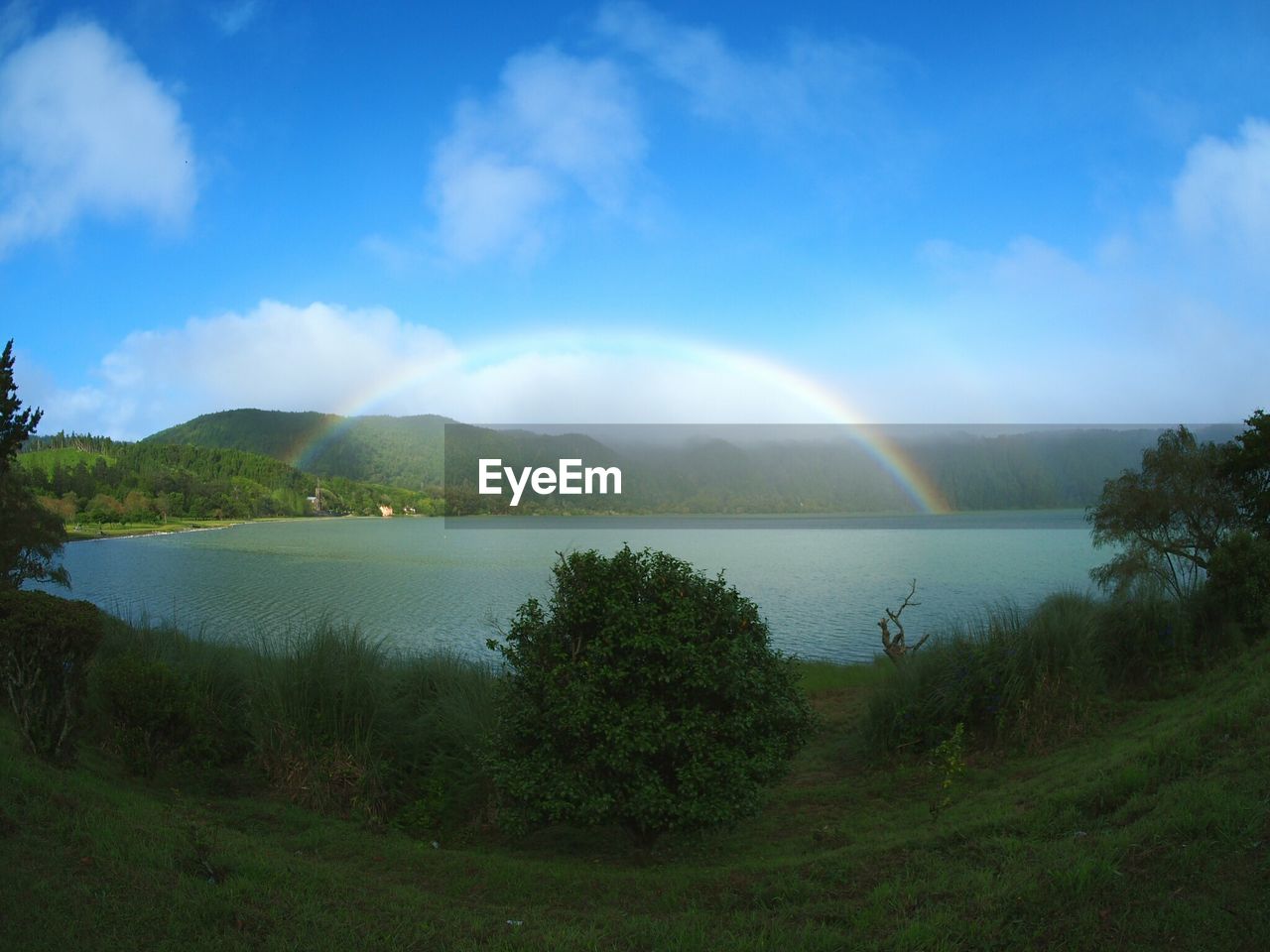 SCENIC VIEW OF LAKE AND RAINBOW AGAINST SKY
