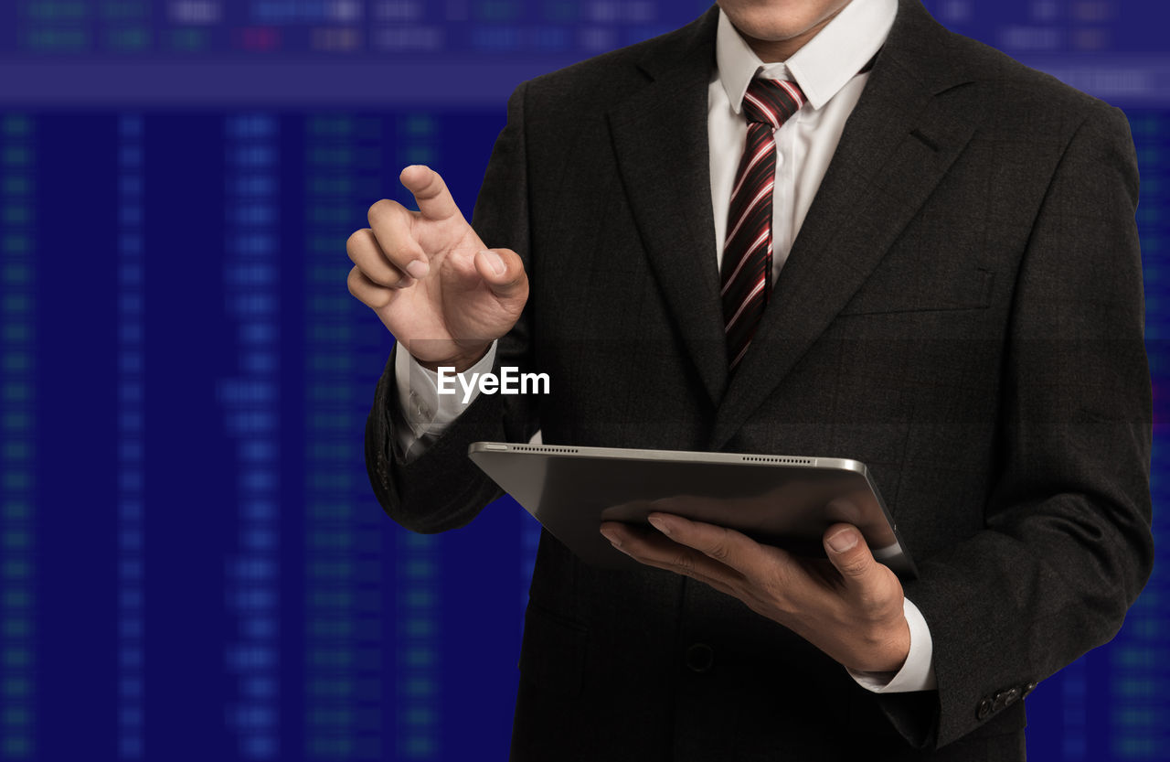 Double exposure of businessman using tablet and stock market charts. financial concept.