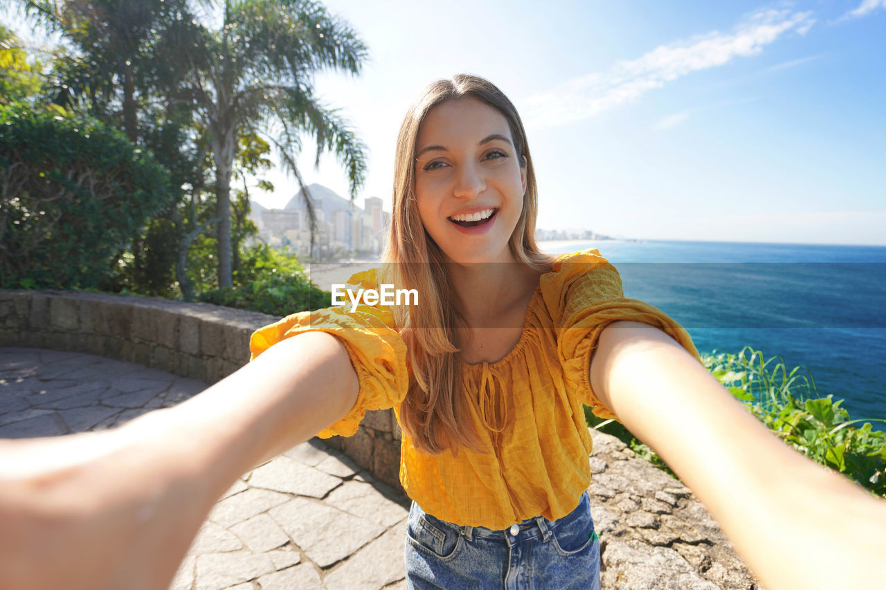 Beautiful smiling young woman takes selfie on belvedere terrace in rio de janeiro, brazil.