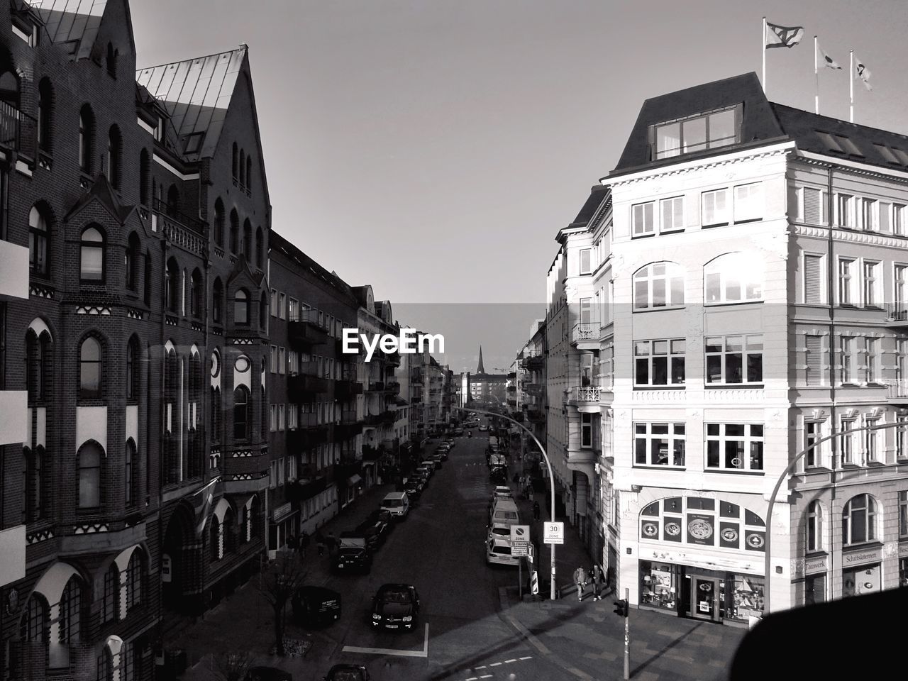 CARS ON CITY STREET AMIDST BUILDINGS AGAINST SKY