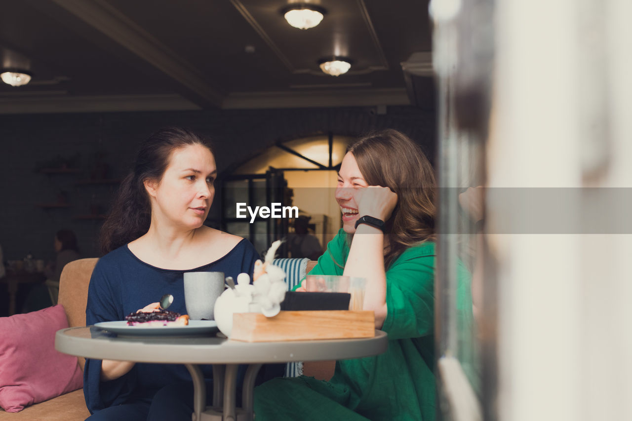 Two women talking and drinking coffee in cafe
