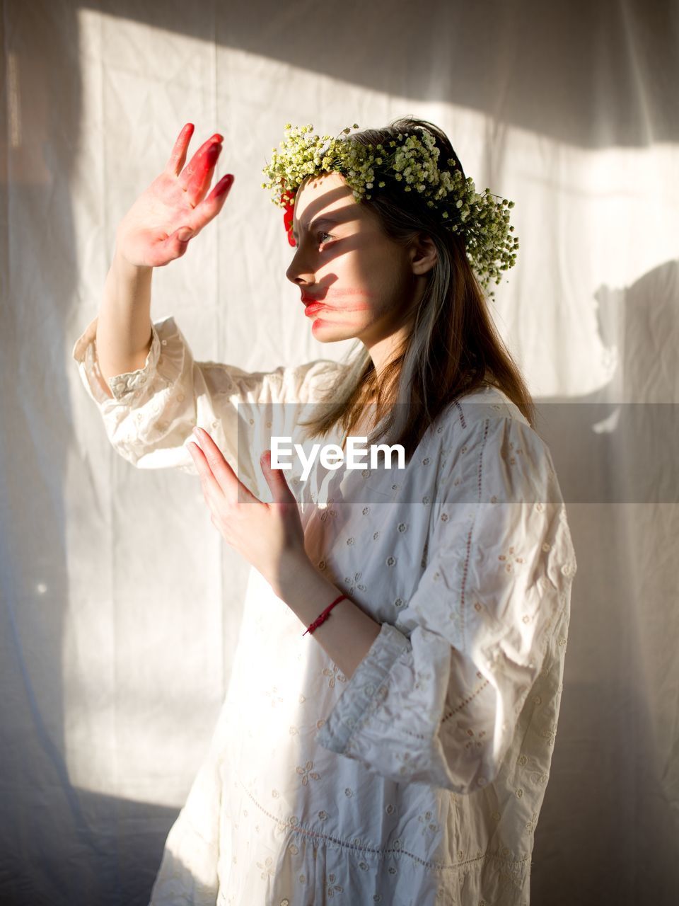 Rear view of young woman standing against wall