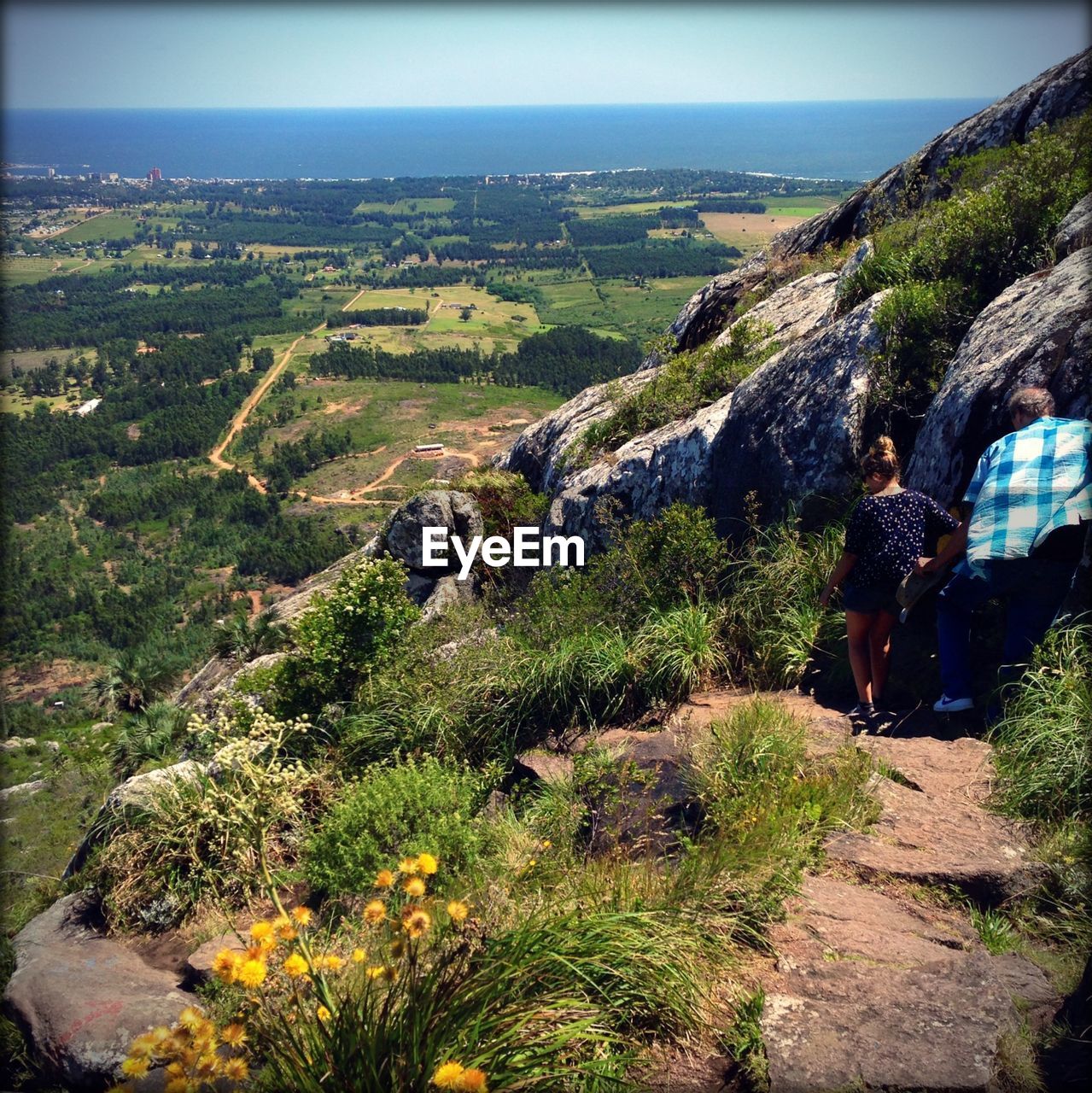 Couple walking by rocks on mountain