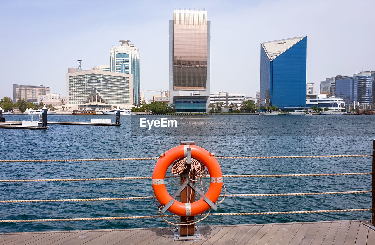 FIRE HYDRANT BY RIVER AGAINST BUILDINGS