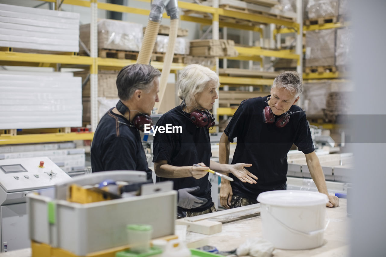 Female workers discussing with colleague while working at industry