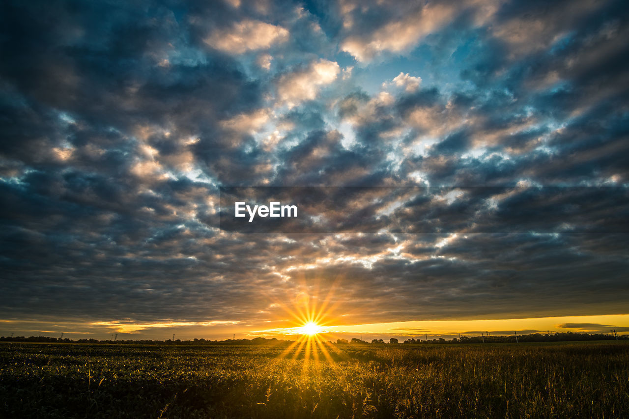 Scenic view of field against dramatic sky