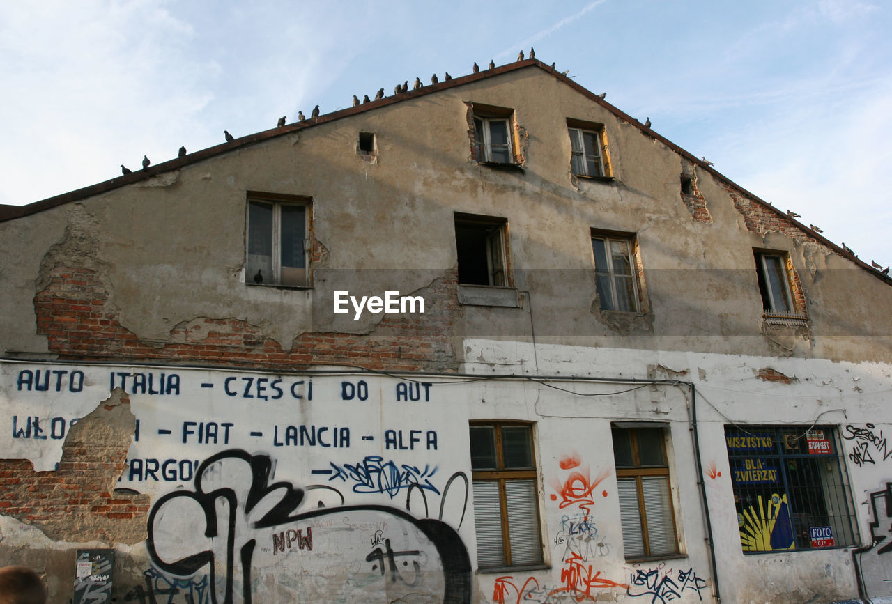 LOW ANGLE VIEW OF TEXT ON BUILDING IN CITY