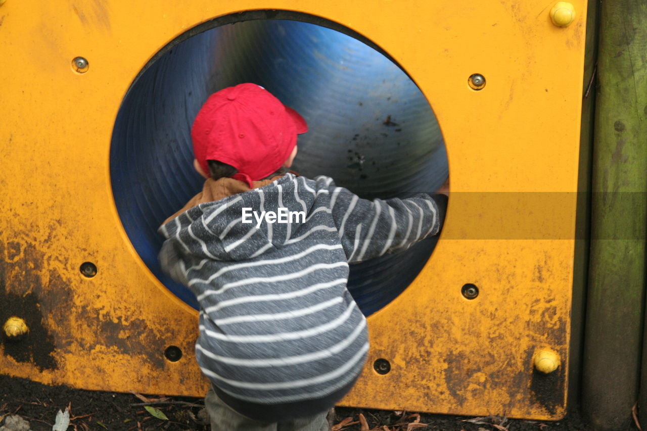 Rear view of a boy looking in tunnel