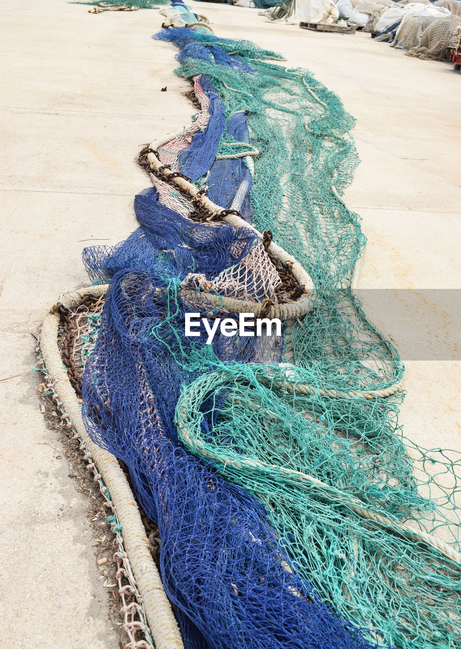 High angle view of fishing net on pavement