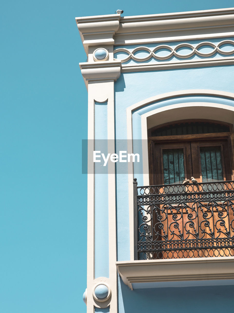 High section of cropped built structure against blue sky