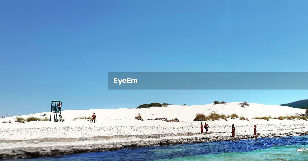 PEOPLE ON SNOWCAPPED MOUNTAIN AGAINST CLEAR BLUE SKY