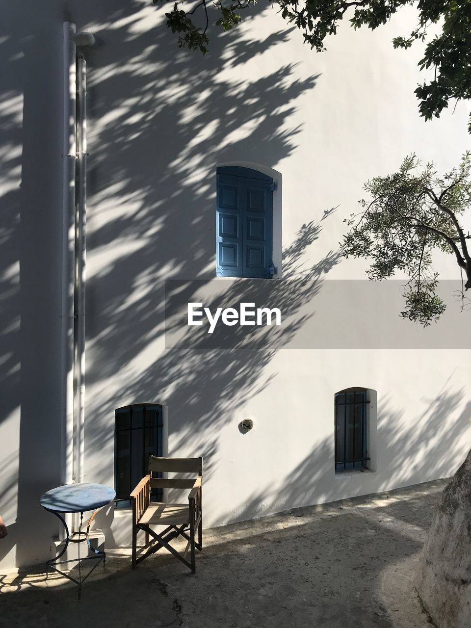 EMPTY CHAIR ON BEACH AGAINST BUILDINGS