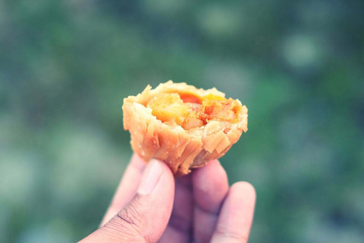 Cropped hand holding kuih