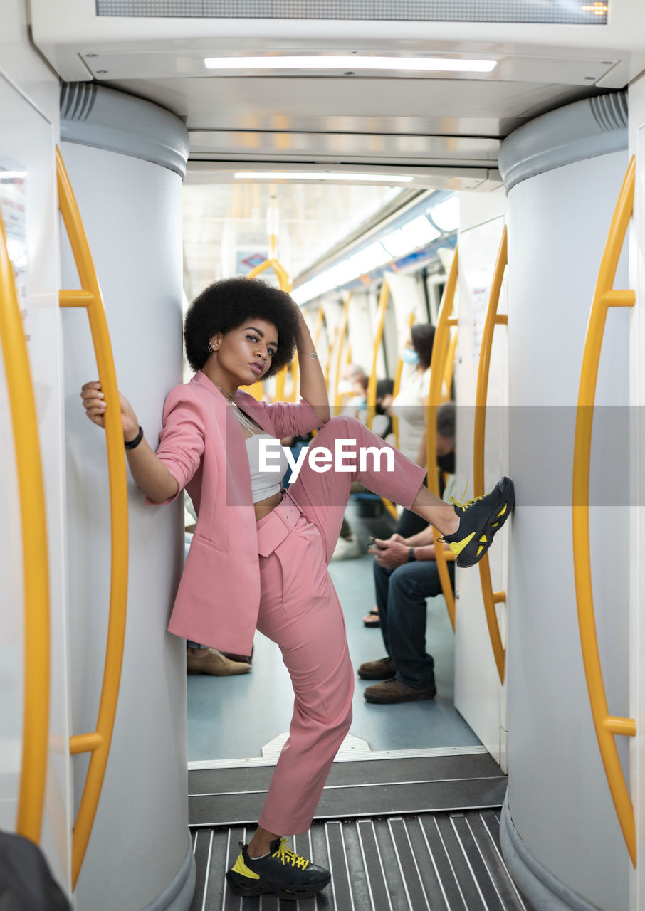 Female hipster with leg-up standing in train