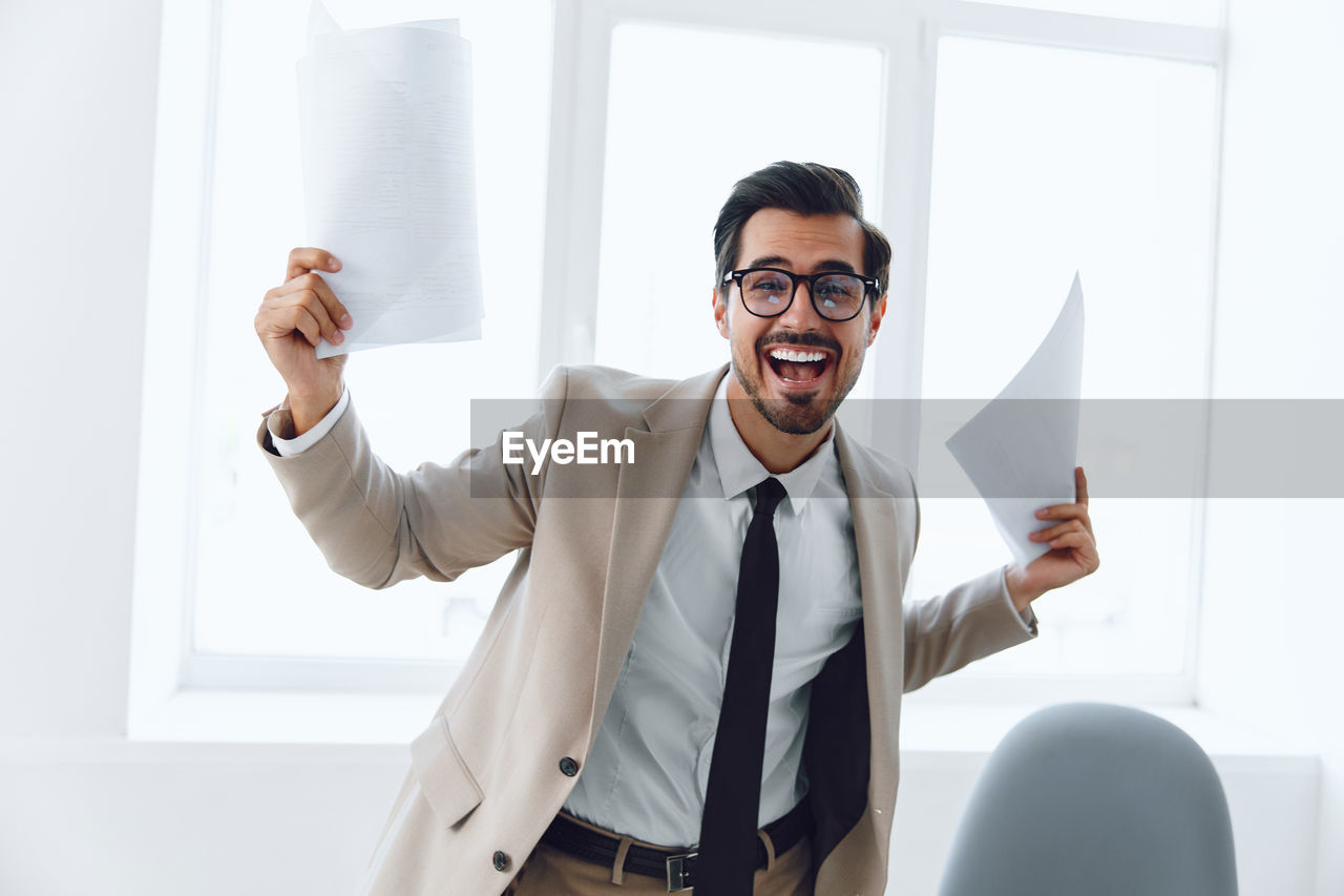 portrait of businessman with arms crossed standing in office