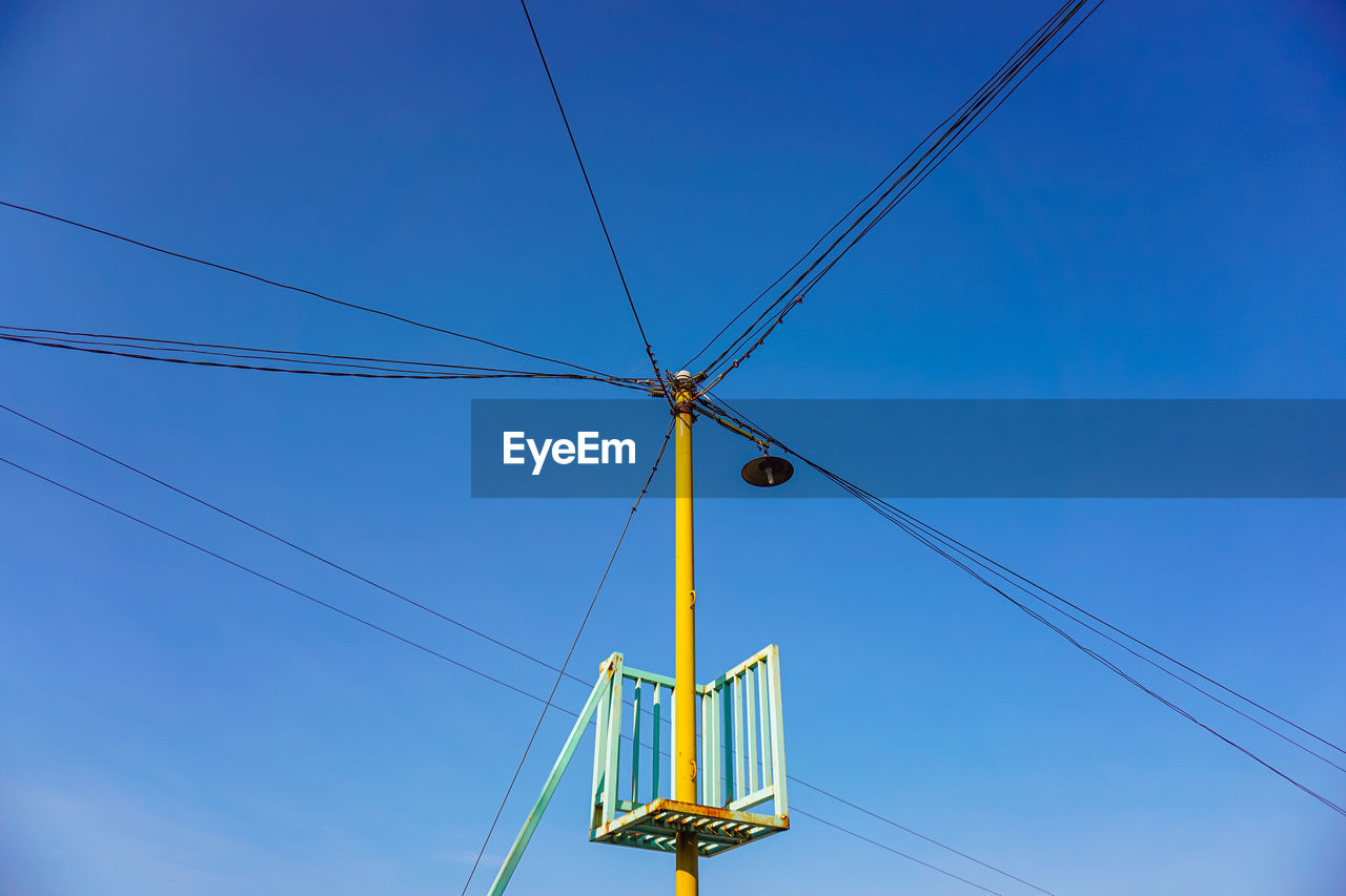 Low angle view of electricity pylon against clear sky