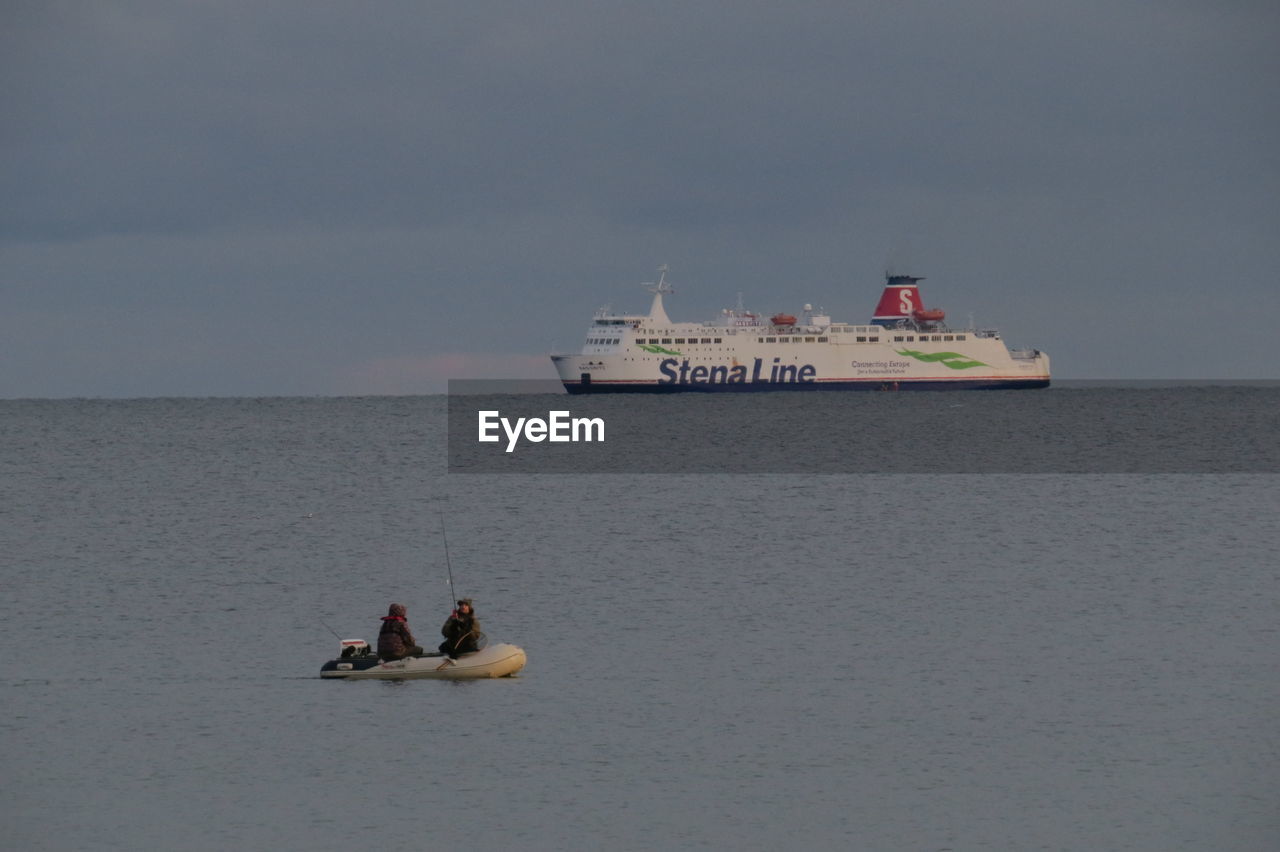 PEOPLE SAILING IN SEA AGAINST SKY