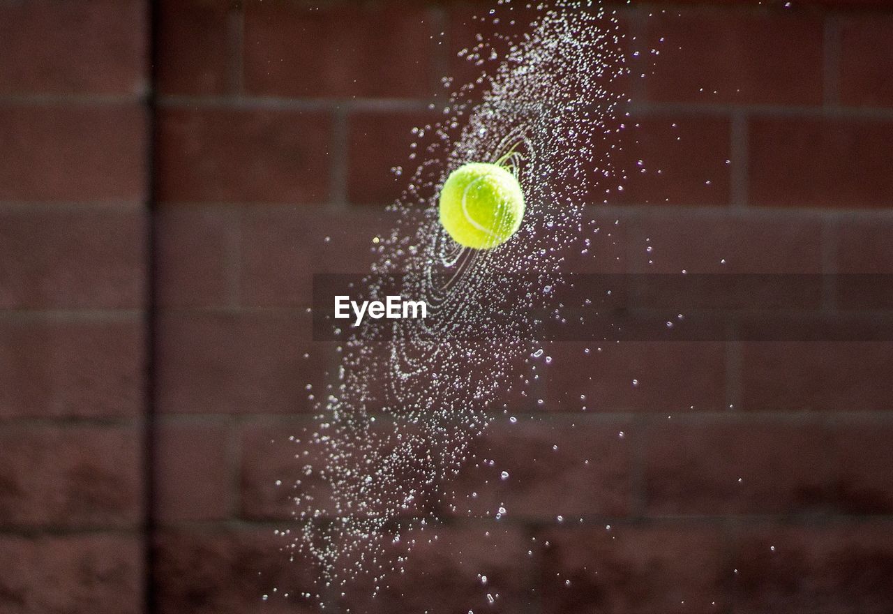 Close-up of tennis ball splashing water 