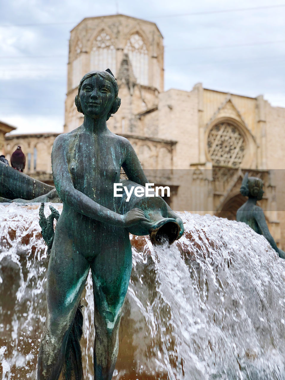 Statue against fountain