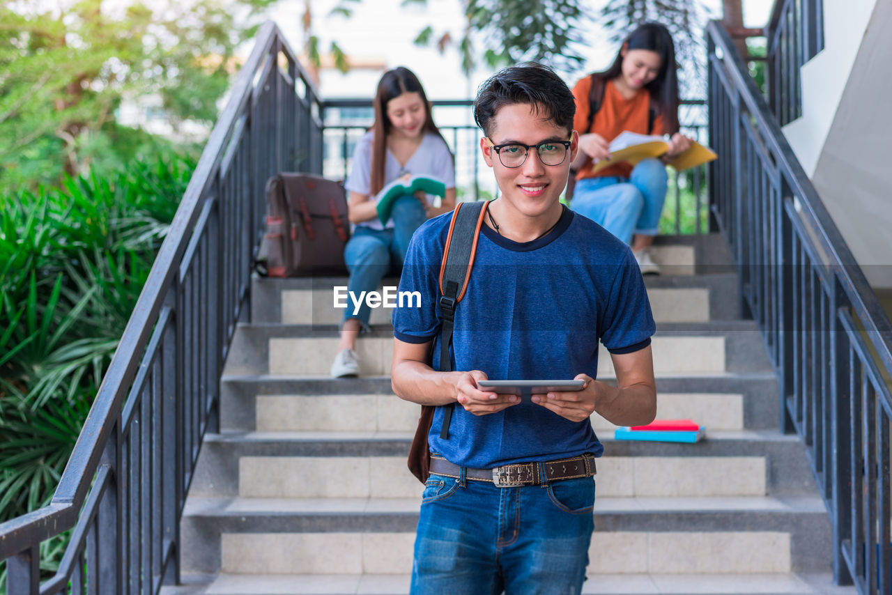 Friends studying while sitting on steps