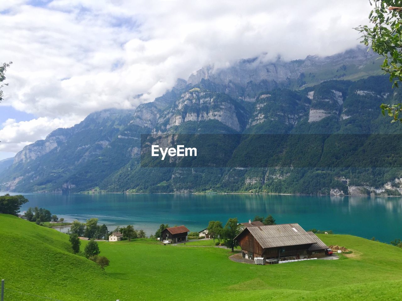 Houses by lake and mountains against sky