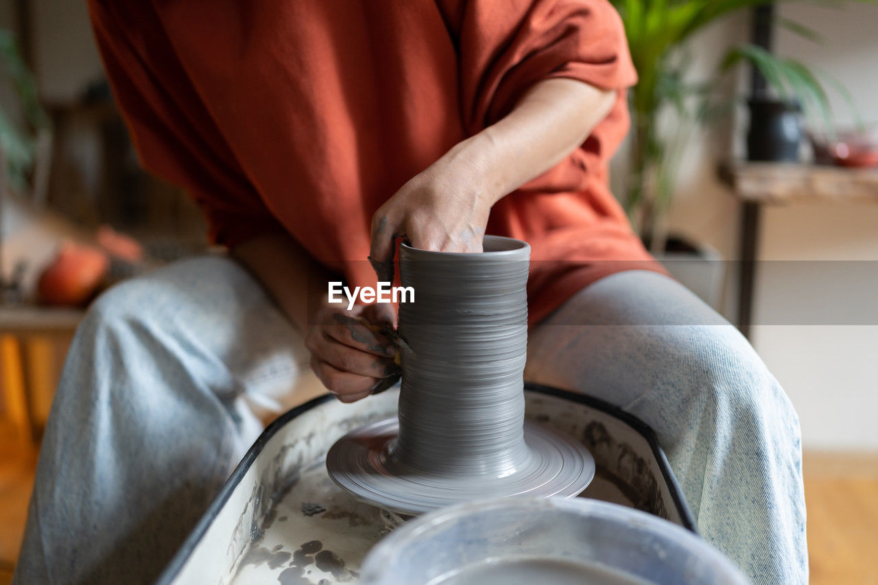 midsection of man working on pottery wheel