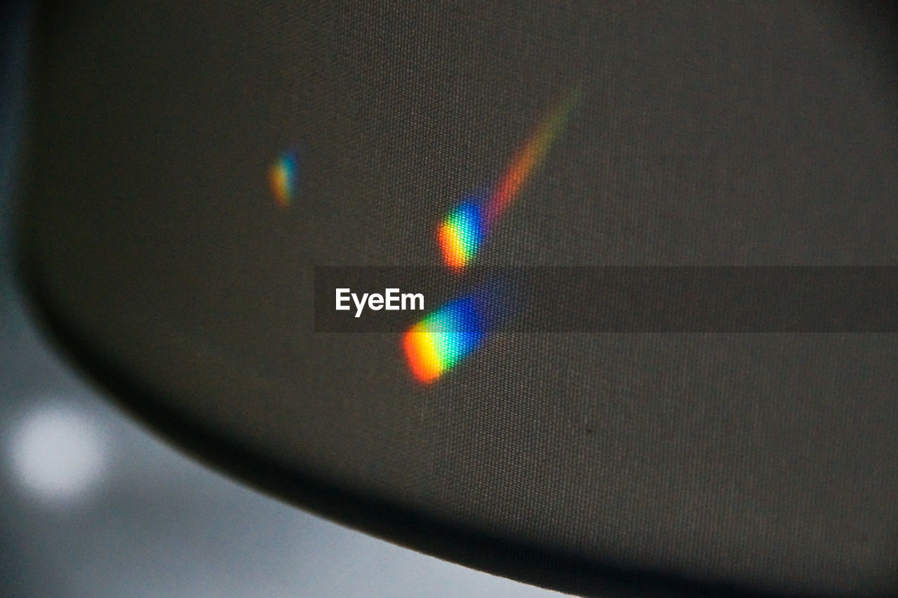 Close-up of multi colored light on black textile