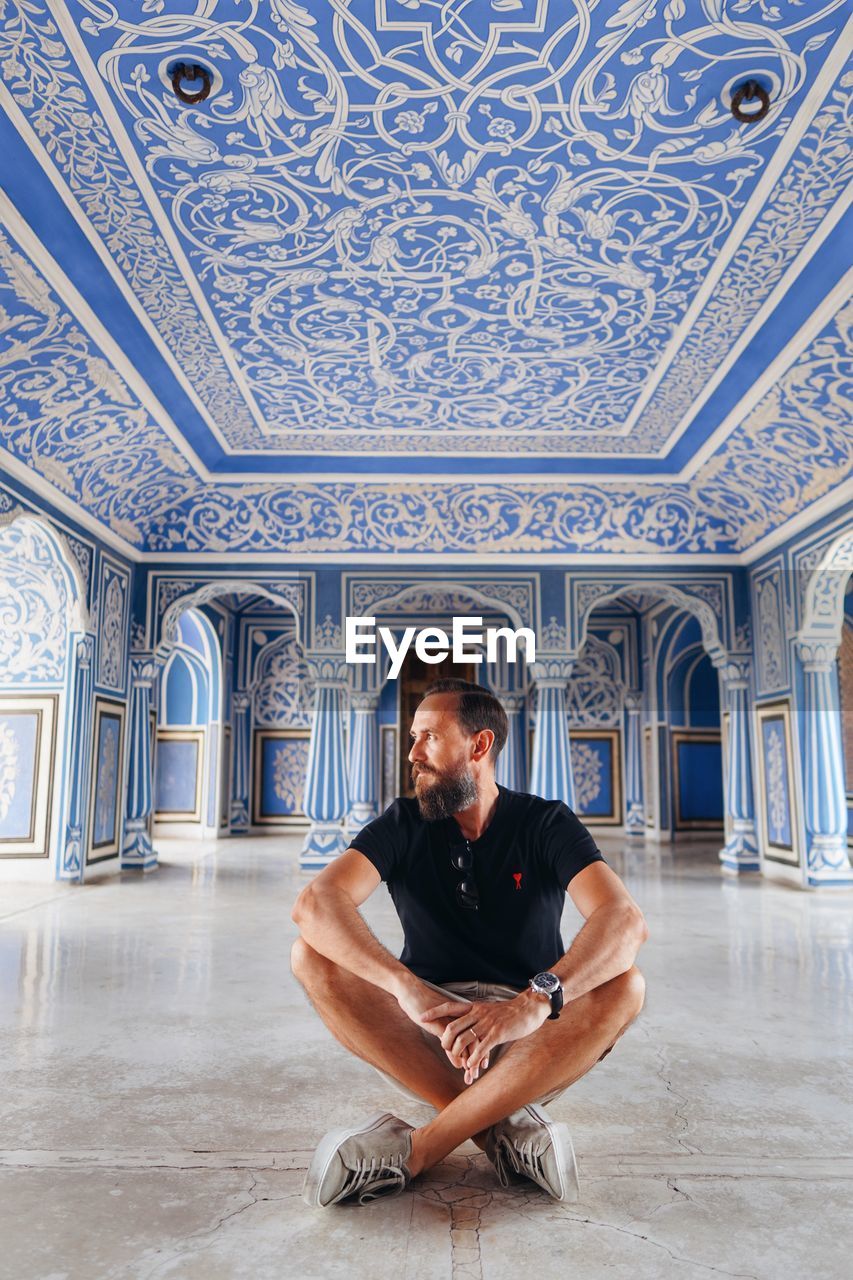 Full length of man sitting on floor in historic building