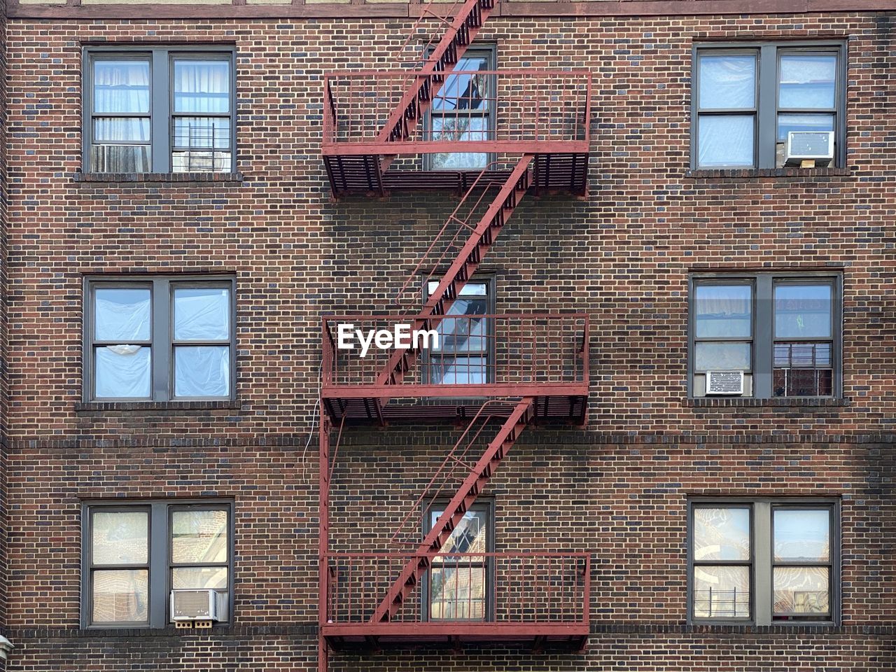 Low angle view of building red fire escape red bricks in mount vernon new york summer 2020