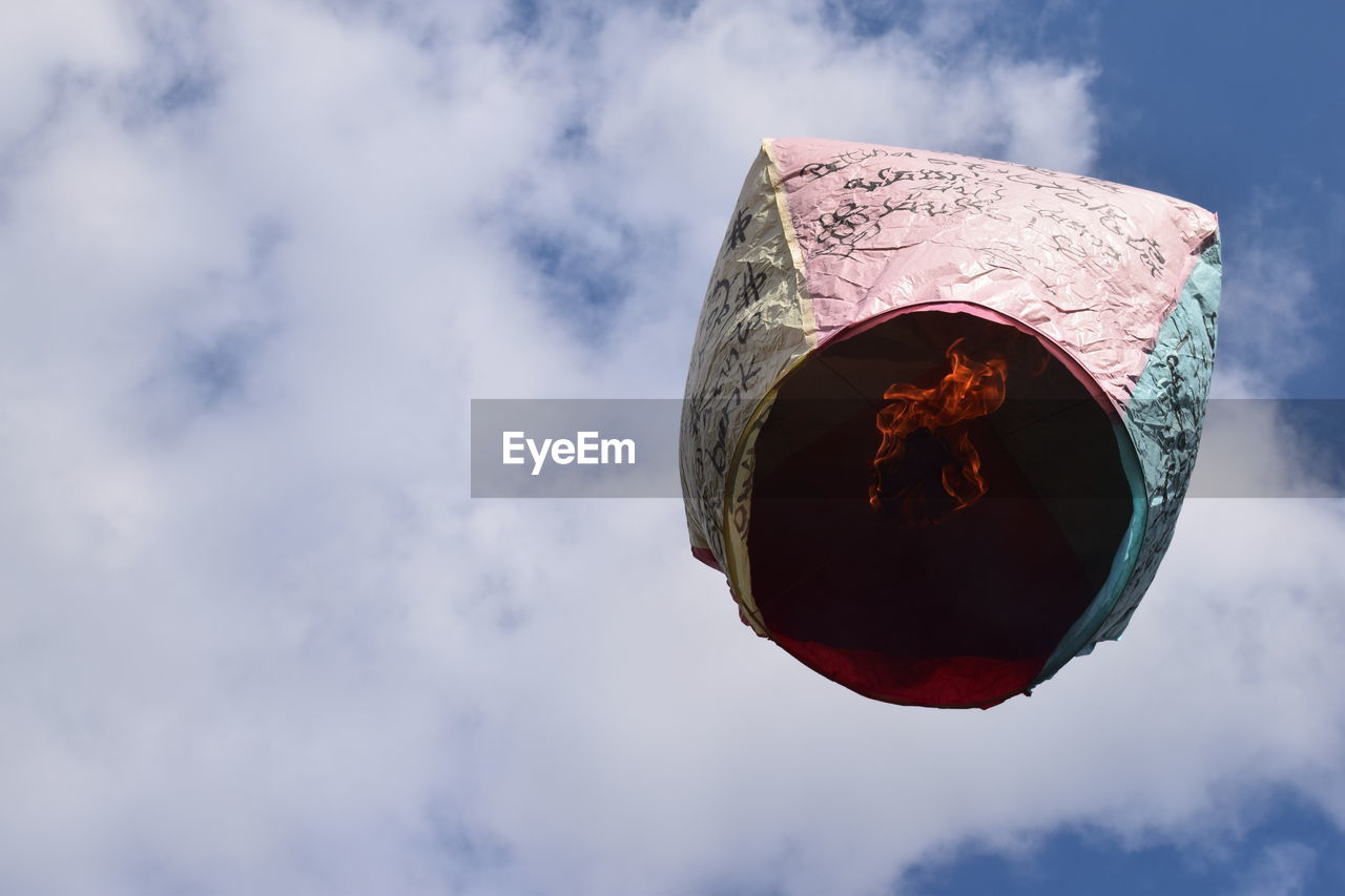 Low angle view of paper lantern flying against sky