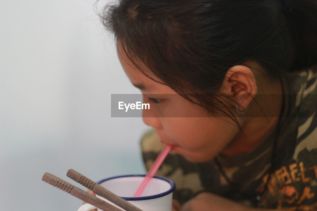 Close-up of girl drinking juice in cup