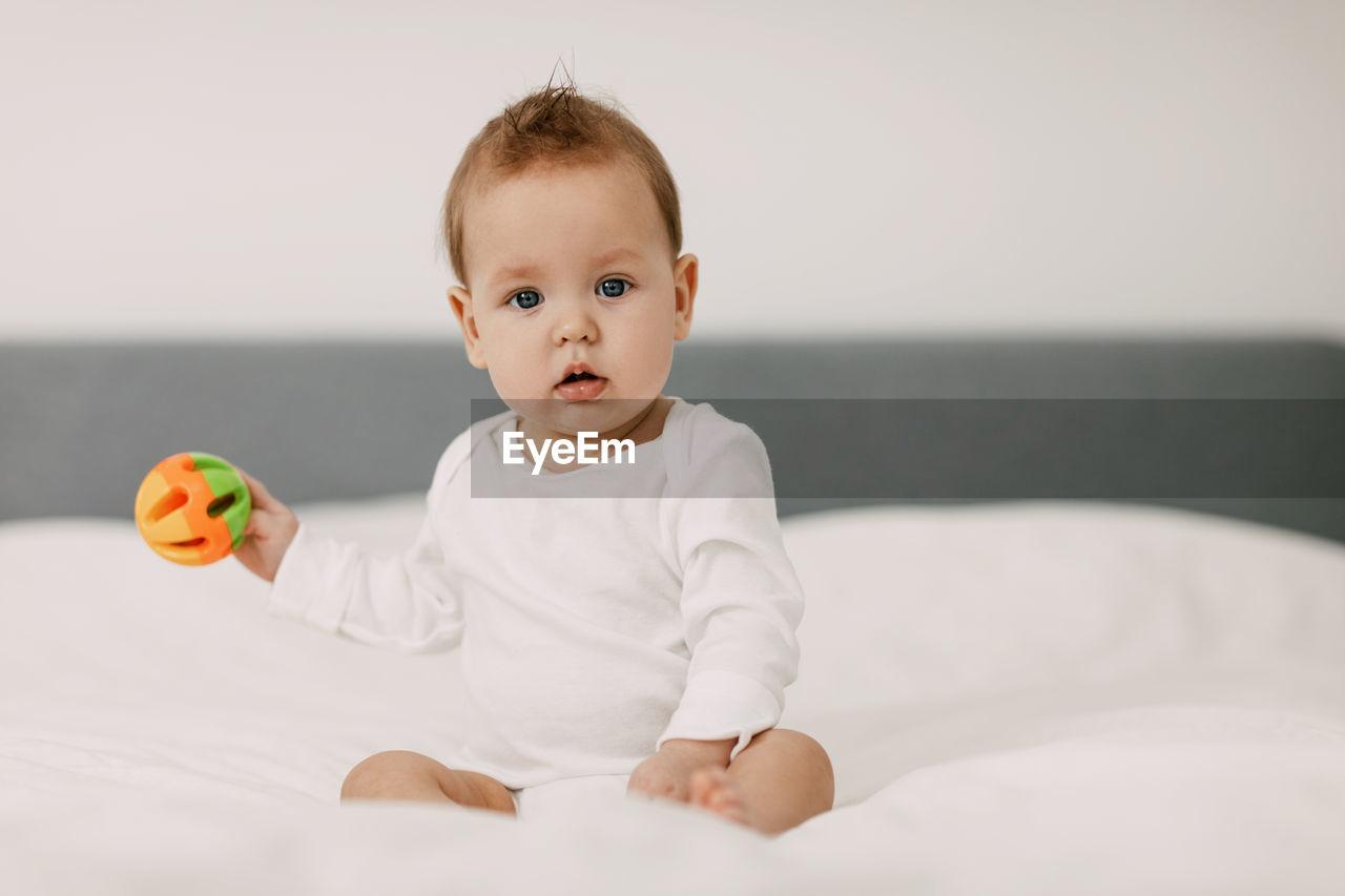 Portrait of cute baby boy on bed