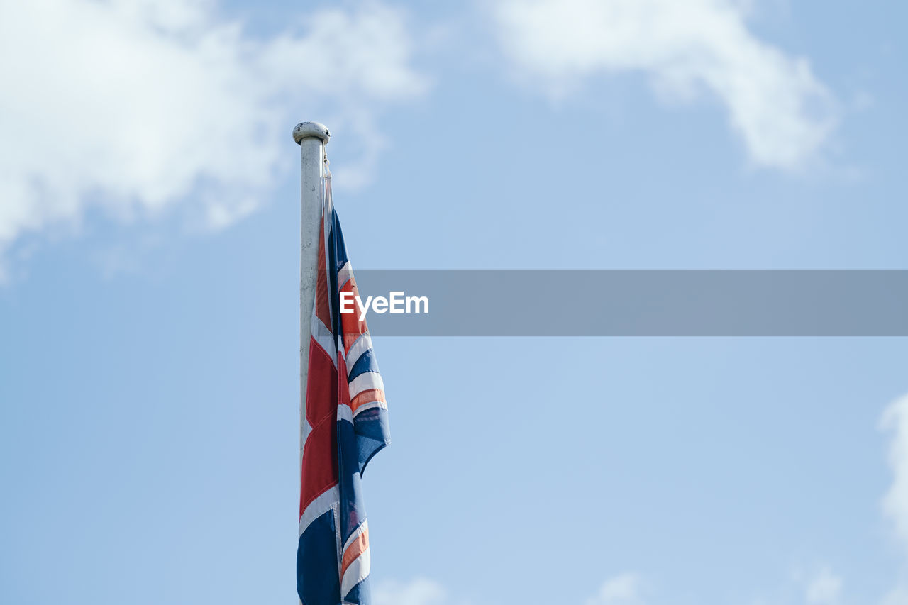 Low angle view of union jack flag against sky