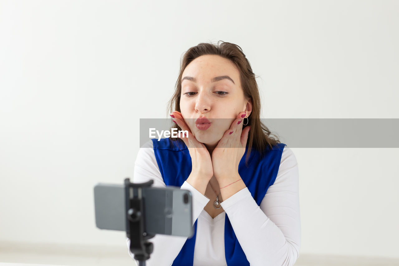 PORTRAIT OF A BEAUTIFUL YOUNG WOMAN WEARING EYEGLASSES