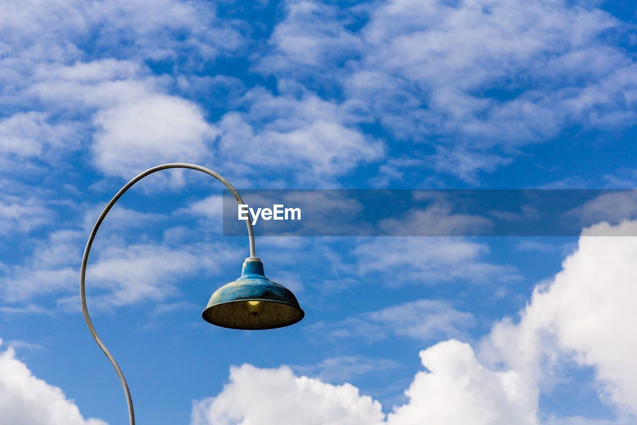 Low angle view of street light against cloudy blue sky