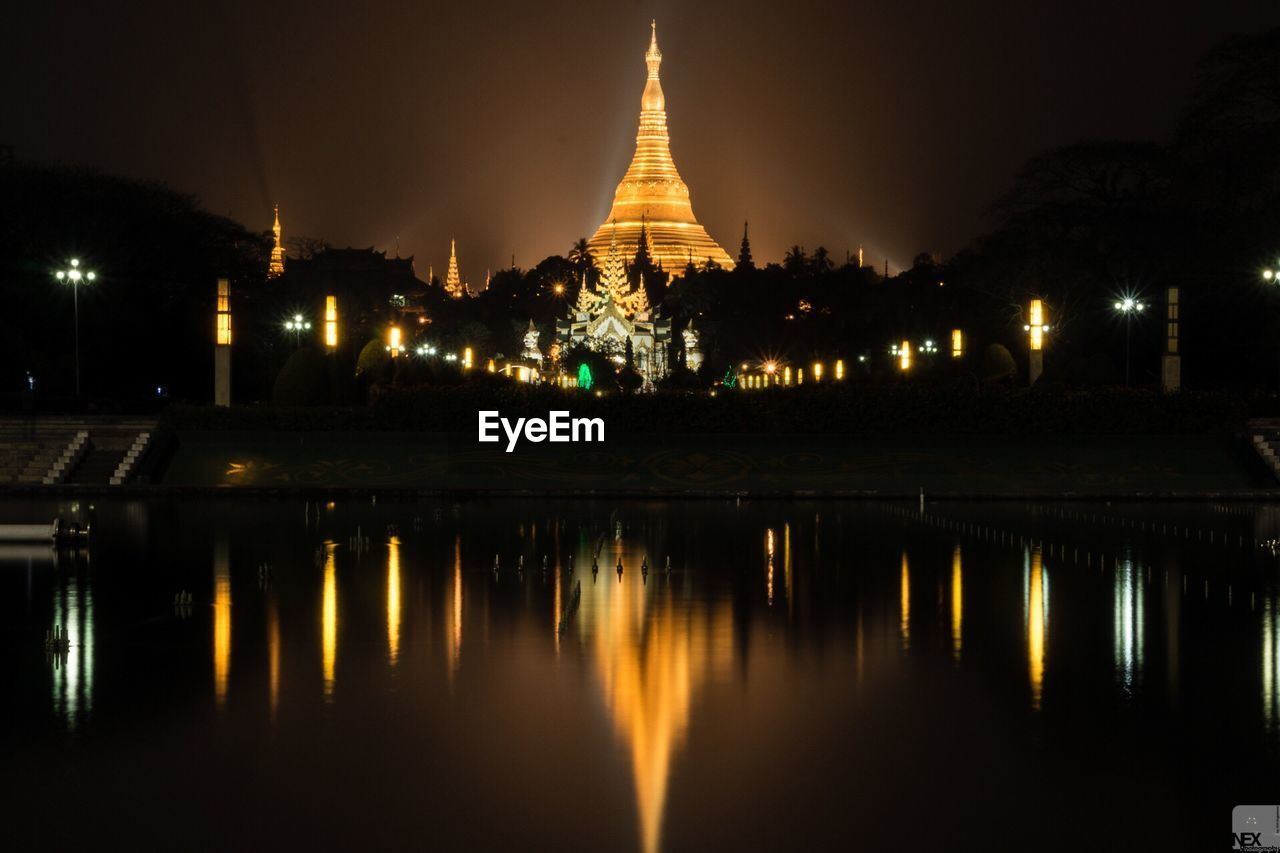 Reflection of illuminated shwedagon pagoda on pond