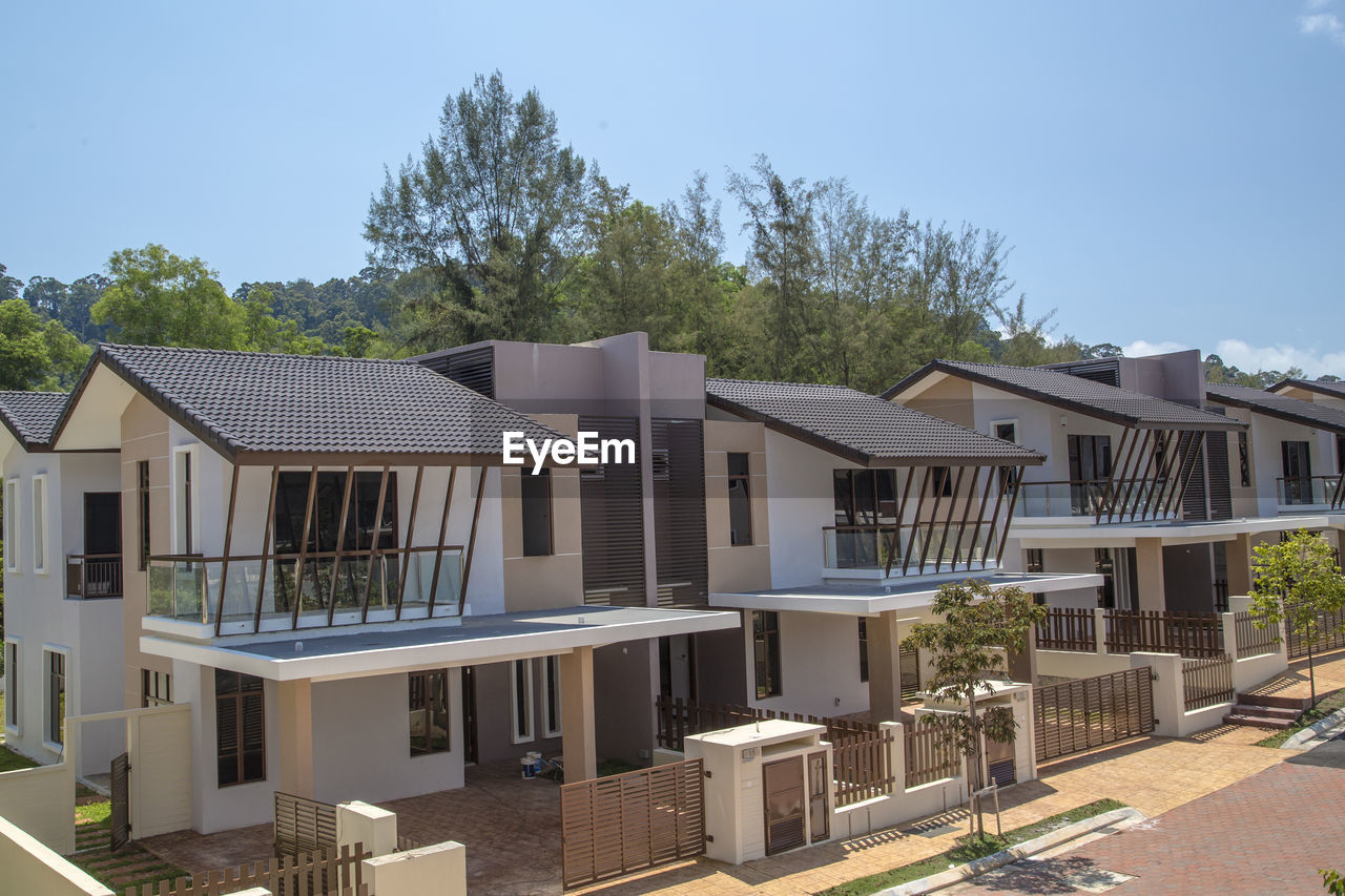 Houses and tables by building against sky