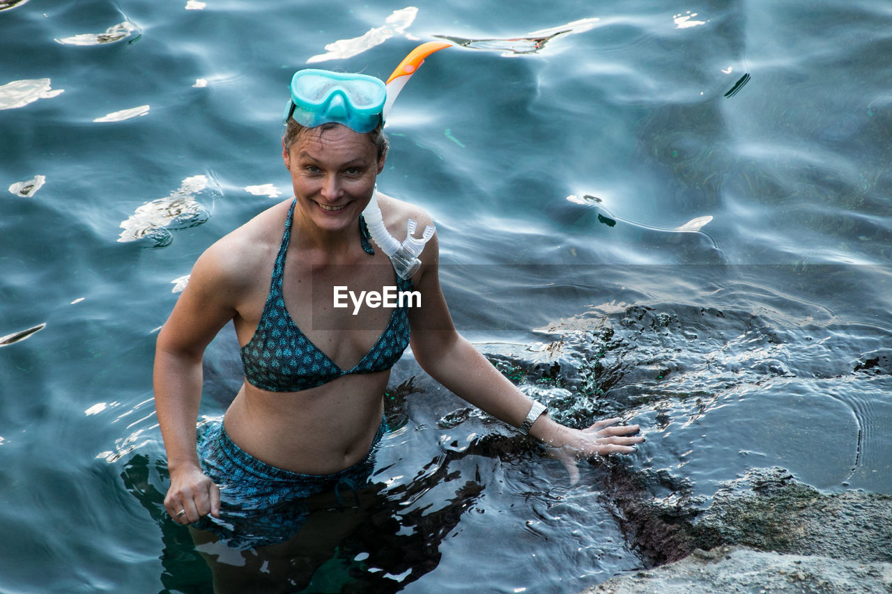 Portrait of smiling young woman snorkeling in sea
