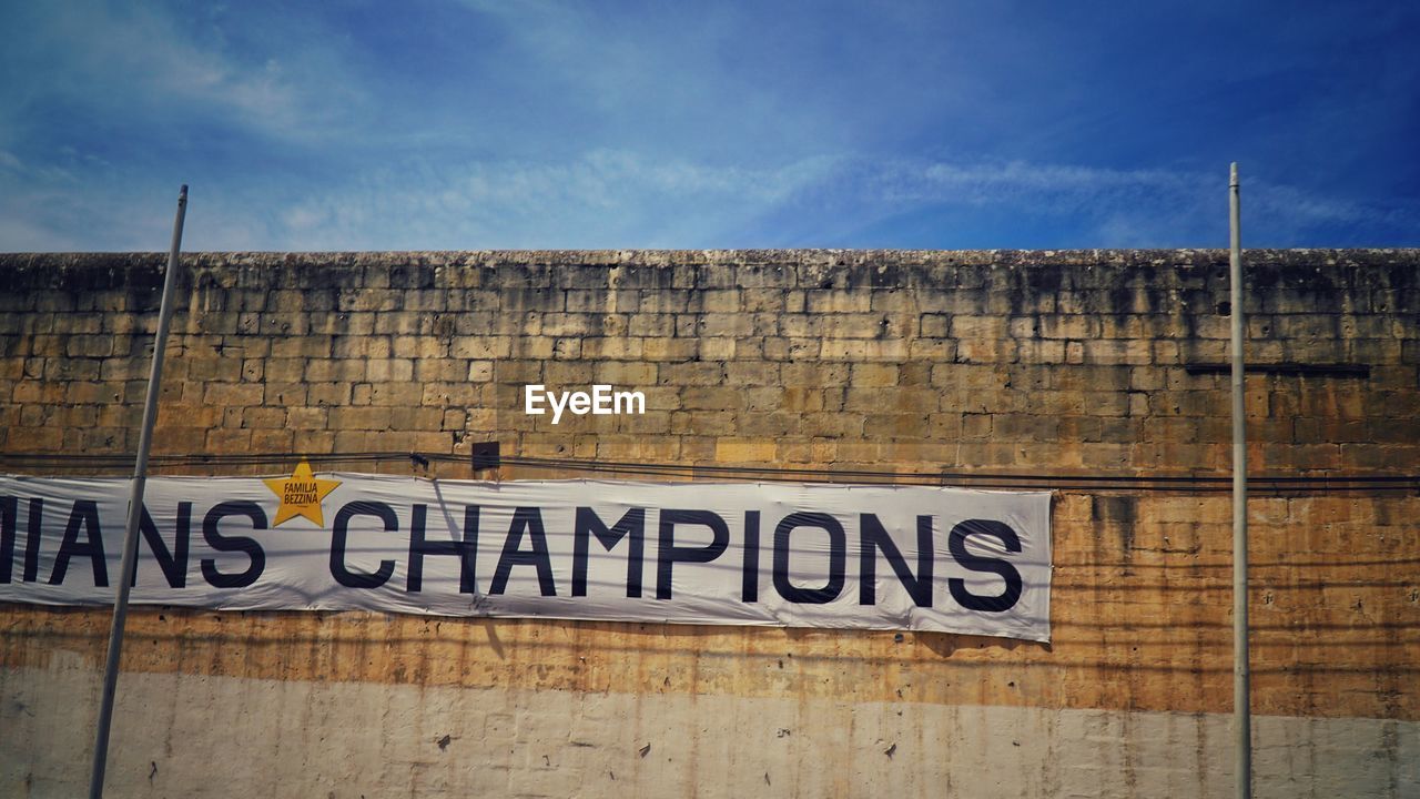 CLOSE-UP OF TEXT ON BRICK WALL