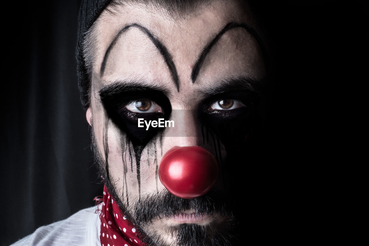 Close-up of man with halloween make-up standing in darkroom