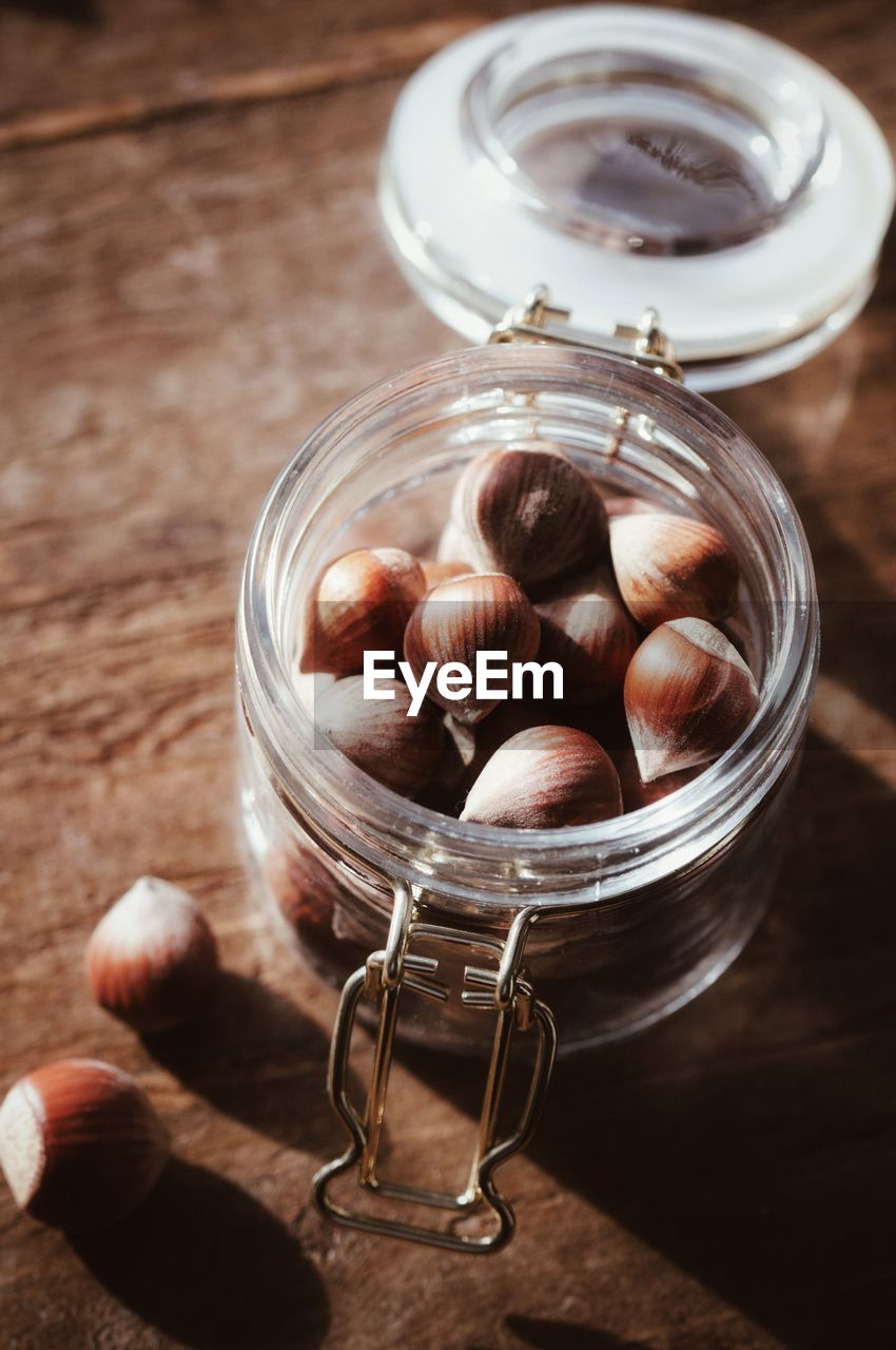 High angle view of hazelnuts in jar on table
